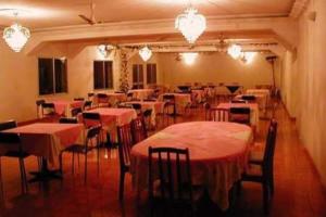 a dining room with tables and chairs and chandeliers at Austral Hotel in Farafangana