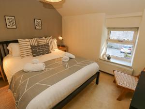 sypialnia z łóżkiem i oknem w obiekcie Flora Cottage w mieście Buxton
