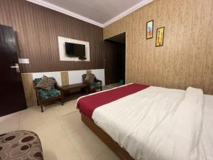 1 dormitorio con 1 cama, mesa y sillas en Hotel Amar, en Mussoorie