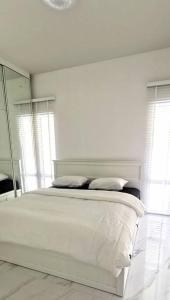 a white bedroom with a bed and a mirror at BaanKuer Hill Pool Villa in Ko Lanta