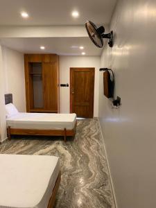 a room with two beds and a television in it at Luxe Inn in Kannur