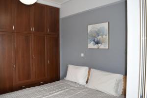 a bedroom with a bed and wooden cabinets at Πολυτελές Διαμέρισμα με Θέα in Sparta