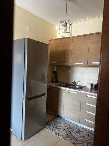 a kitchen with a stainless steel refrigerator and a sink at Πολυτελές Διαμέρισμα με Θέα in Sparta