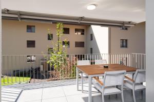 - un balcon avec une table et des chaises dans l'établissement Neubauwohnung mit Lift in Matten, à Matten