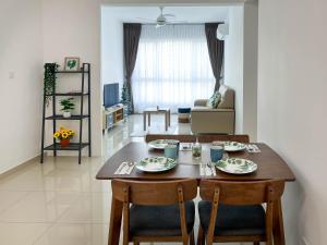 ein Esszimmer und ein Wohnzimmer mit einem Tisch und Stühlen in der Unterkunft Seaview Private Master Bedroom in a Shared Unit in Tanjong Tokong