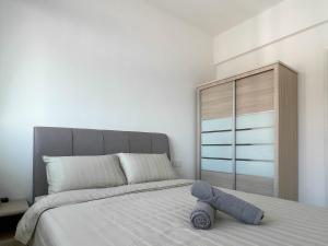 ein Schlafzimmer mit einem Bett mit einem Teddybär drauf in der Unterkunft Seaview Private Master Bedroom in a Shared Unit in Tanjong Tokong