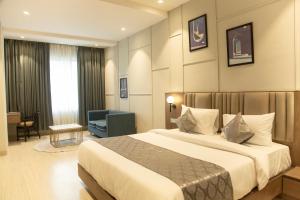um quarto de hotel com uma cama e uma cadeira em Hotel Westend em Udaipur