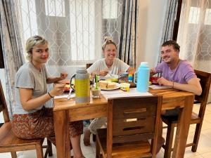 a group of people sitting around a wooden table at Serene Abodes in Zanzibar City