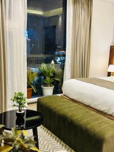 1 dormitorio con cama, mesa y ventana en ROYAL ACE LUXUR en Bangalore