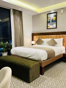 um quarto de hotel com uma cama grande e uma janela em ROYAL ACE LUXUR em Bangalore