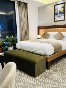 a hotel room with two beds and a chair at ROYAL ACE LUXUR in Bangalore