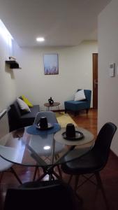 ein Wohnzimmer mit 2 Tischen und Stühlen mit Hüten darauf in der Unterkunft Elegante Departamento in La Paz