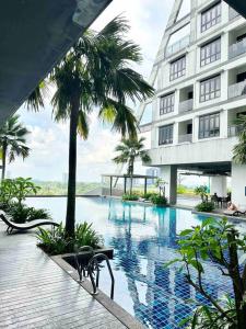 a large building with a swimming pool in front of a building at 1320 Meridin Cozy Legoland Netflix By STAY in Nusajaya