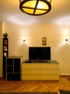 a living room with a flat screen tv on a dresser at Heliopolis Rock Residence in Cairo