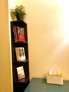a book shelf with books and a box on a table at Heliopolis Rock Residence in Cairo