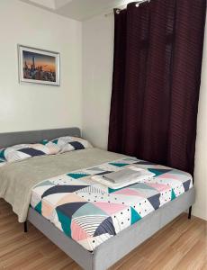 1 Schlafzimmer mit 2 Betten und einem Fenster in der Unterkunft Neat Unit in Holland Park Southwoods in Biñan