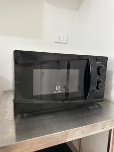 a microwave oven sitting on top of a table at Neat Unit in Holland Park Southwoods in Biñan