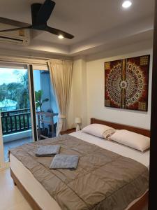 a bedroom with a large bed with a ceiling fan at Khanom Beach Residence Monthly Rental Condo in Khanom