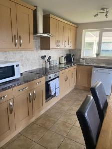 a kitchen with wooden cabinets and a stove top oven at Bungalow in Pillaton in Saltash