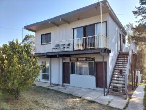 a house with a staircase in front of it at Surfside two-bedroom holiday upstairs in Batemans Bay