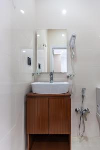 uma casa de banho com um lavatório e um espelho em Hillside City Center Hotel em Baku