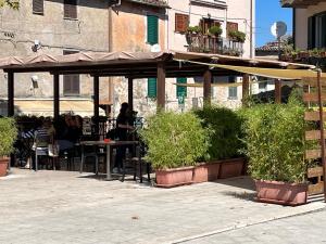 un patio avec des personnes assises à une table sous un parasol dans l'établissement Short let SanRocco, à Olevano Romano