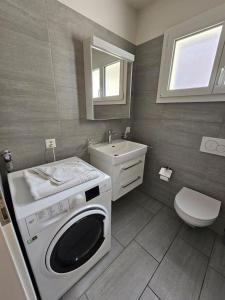 ein Badezimmer mit einer Waschmaschine und einem Waschbecken in der Unterkunft Rustico in pietra in Brissago
