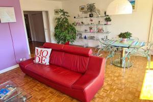 ein rotes Sofa im Wohnzimmer mit einem Tisch in der Unterkunft 3 room apartment, 90 sqm, quiet, 25 min from Paris in Le Vésinet