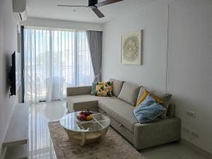 a living room with a couch and a glass table at Cassia Residences 1 in Bang Tao Beach