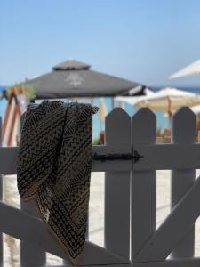 a bag is hanging on a white fence at Beachfront House Pythagorion in Pythagoreio