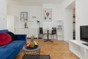 a living room with a blue couch and a table at Bright & Modern Studio in Łódź Classic Tenement House by Renters in Łódź