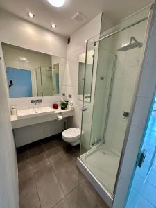 a bathroom with a shower and a toilet and a sink at Wroclove Tumski Apartment in Wrocław