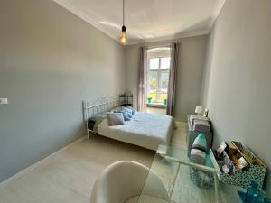 a small bedroom with a bed and a window at Wroclove Tumski Apartment in Wrocław