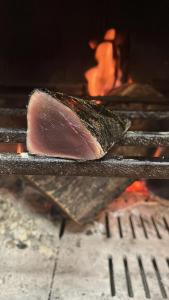 un pedazo de carne está cocinando en una parrilla en Casa rural marga, en Tardienta