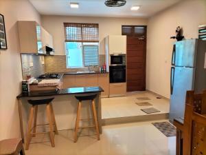 a kitchen with a counter and a refrigerator at Square One CONDO - Kelaniya in Kiribathgoda