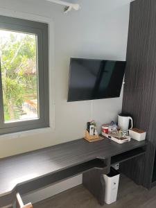 a desk with a television on a wall with a window at NAI Homestay in Ben Tre
