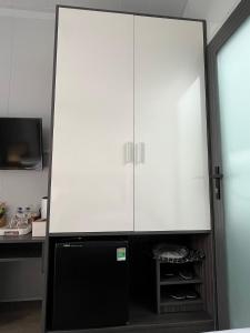a black refrigerator with a white cabinet in a kitchen at NAI Homestay in Ben Tre