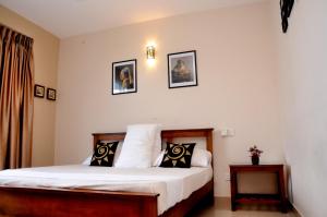 a bedroom with a bed and two pictures on the wall at Square One CONDO - Kelaniya in Kiribathgoda
