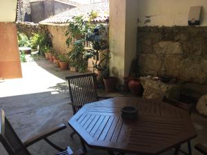 een houten tafel en stoelen op een patio met planten bij Habitación en A Armenteira ideal peregrinos in Meis