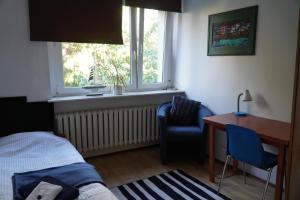 um quarto com uma cama, uma secretária e uma janela em Apartament Paderewski em Poznań
