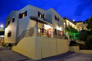 a white house with a balcony at night at Melitta Villa in Ágios Ioánnis