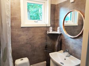 a bathroom with a sink and a mirror and a toilet at Nice holiday home in cozy Billdal in Billdal