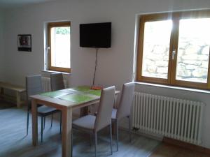 ein Esszimmer mit einem Tisch, Stühlen und einem TV in der Unterkunft Apartment Herdrich in Rust