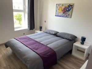 1 dormitorio con 1 cama grande con manta morada en Les Gîtes de La Vieille Roue - Gite 3, en Reignac