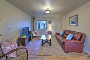 a living room with a leather couch and a coffee table at Anacortes Condo - Walk to Town, Marina, and Bay! in Anacortes