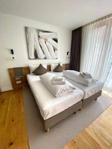 a bedroom with two beds and a painting on the wall at Luxury Mountain Hotel Apartment in Andermatt