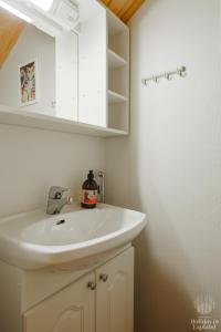 une salle de bain avec un lavabo blanc et un miroir dans l'établissement Holiday in Lapland - Levin Sudenpesä, à Levi 17 autres photos