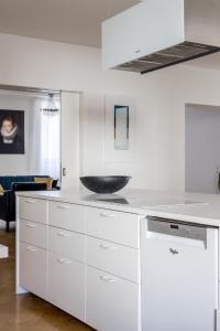 eine Küche mit weißen Schränken und einer Schale auf der Theke in der Unterkunft Elegant City Home in Helsinki