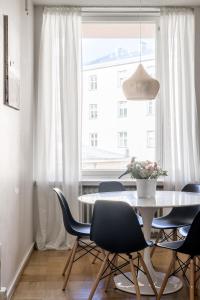 ein Esszimmer mit einem Tisch, Stühlen und einem Fenster in der Unterkunft Elegant City Home in Helsinki