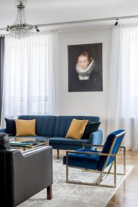 uma sala de estar com um sofá azul e um quadro em Elegant City Home em Helsinque